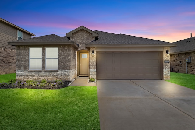 prairie-style house featuring a yard and a garage