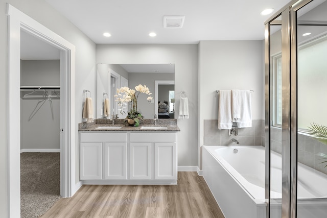 bathroom with vanity, plus walk in shower, and hardwood / wood-style flooring