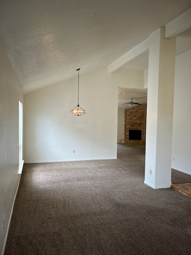 carpeted spare room featuring lofted ceiling, a textured ceiling, a fireplace, and ceiling fan