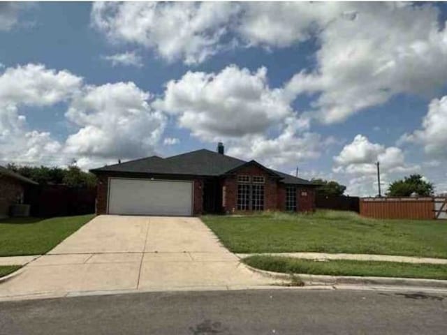 ranch-style house with a garage and a front lawn