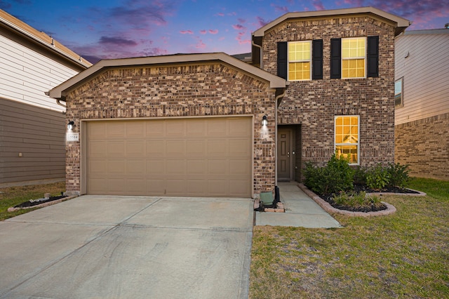 view of front of property with a yard and a garage