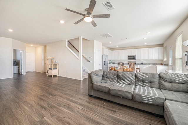 living room with ceiling fan and dark hardwood / wood-style flooring