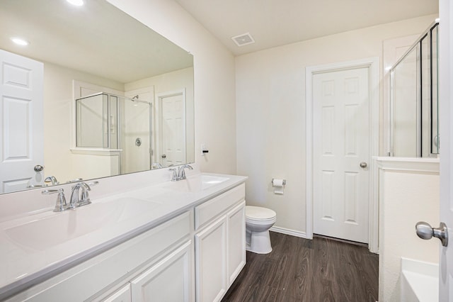 bathroom with vanity, hardwood / wood-style floors, toilet, and walk in shower