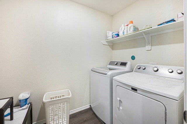 clothes washing area featuring washer and clothes dryer and dark hardwood / wood-style flooring