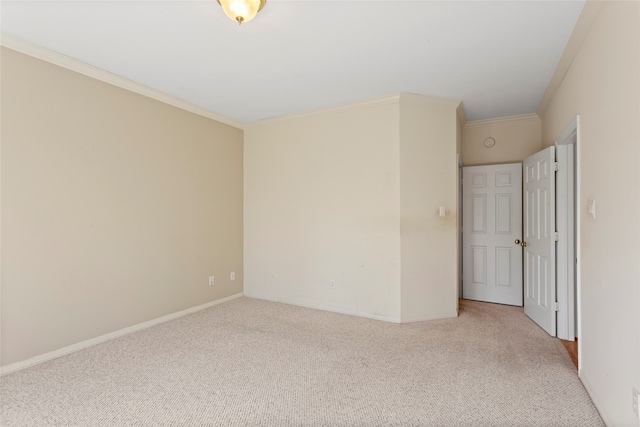 empty room with carpet floors, ornamental molding, and baseboards