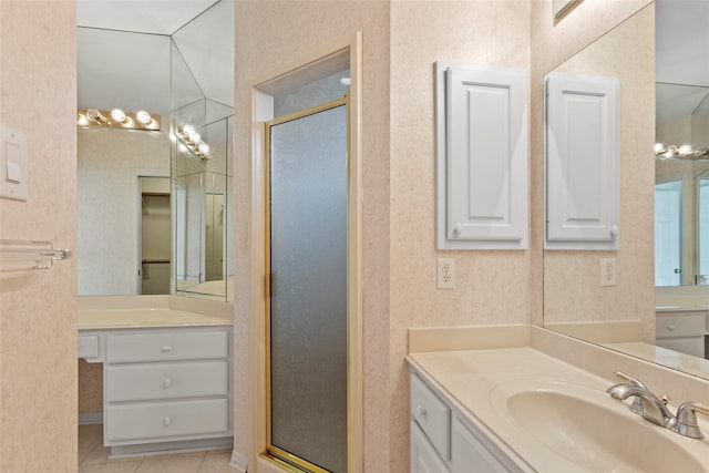 full bath featuring a shower stall, two vanities, and tile patterned flooring