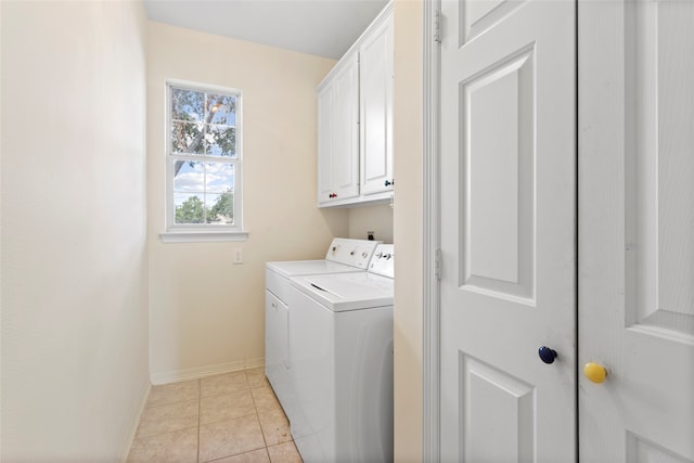 laundry room with cabinet space, washing machine and dryer, baseboards, and light tile patterned floors