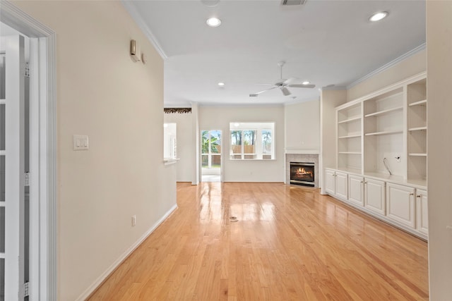 unfurnished living room featuring crown molding, a ceiling fan, a fireplace, light wood-style flooring, and recessed lighting