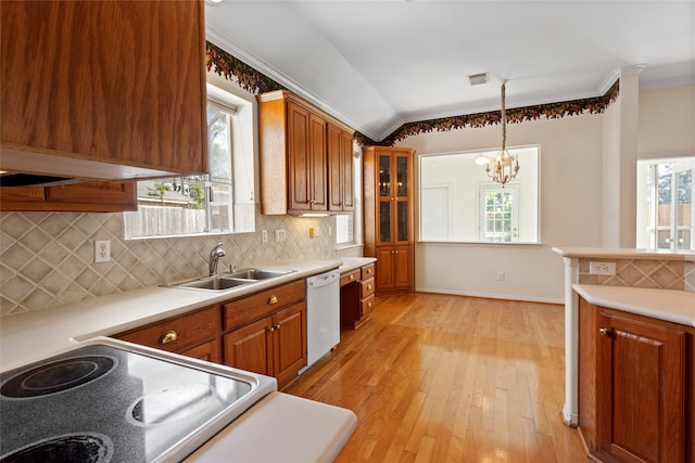 kitchen with an inviting chandelier, stove, white dishwasher, light wood-type flooring, and sink