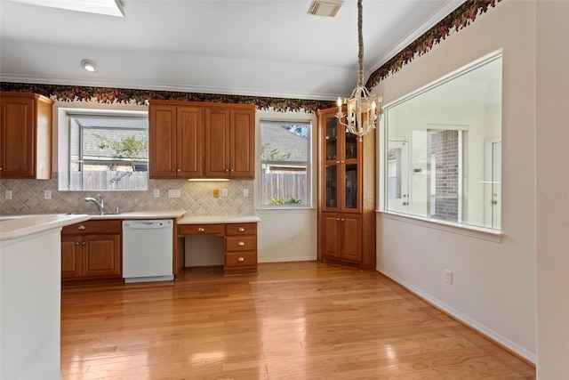 kitchen with sink, dishwasher, backsplash, light hardwood / wood-style floors, and pendant lighting