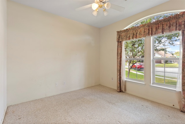 empty room featuring carpet flooring, plenty of natural light, a ceiling fan, and baseboards