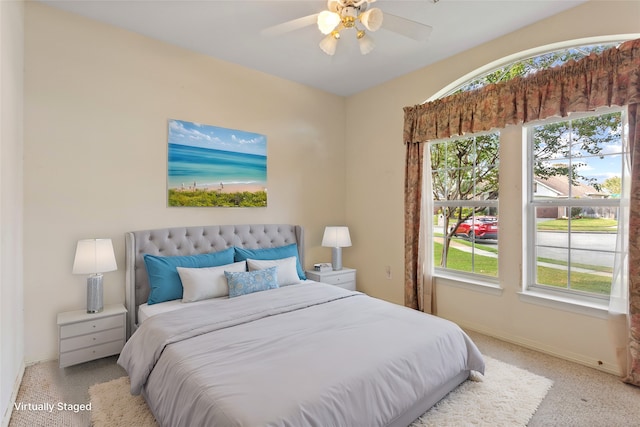 carpeted bedroom with multiple windows and ceiling fan