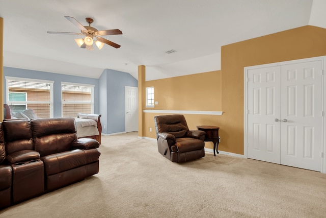 carpeted living room featuring ceiling fan and vaulted ceiling