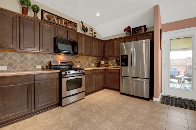 kitchen featuring backsplash, stainless steel appliances, dark brown cabinetry, and vaulted ceiling