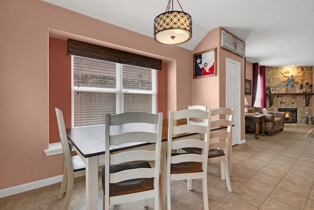 dining space with a fireplace and light tile patterned floors