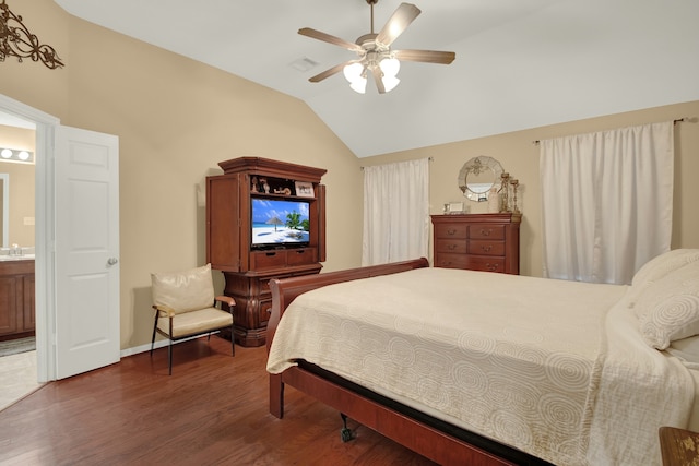 bedroom featuring lofted ceiling, ensuite bath, dark wood-type flooring, and ceiling fan