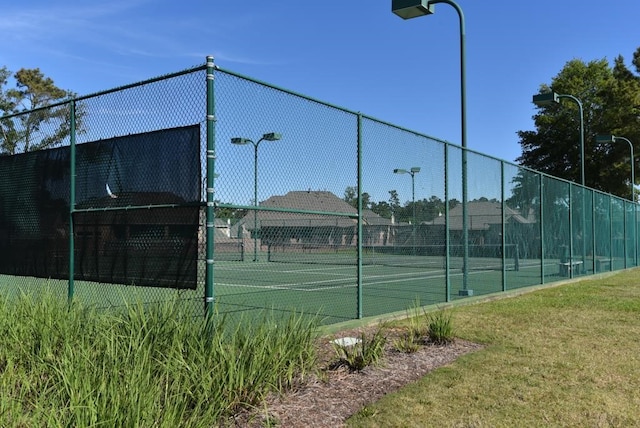 view of tennis court with a yard