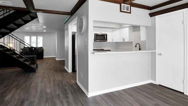 kitchen with sink, kitchen peninsula, white cabinetry, beamed ceiling, and dark hardwood / wood-style floors