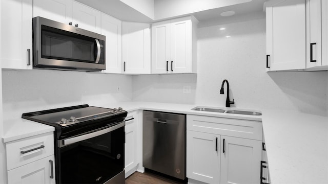 kitchen featuring sink, white cabinets, dark wood-type flooring, and stainless steel appliances