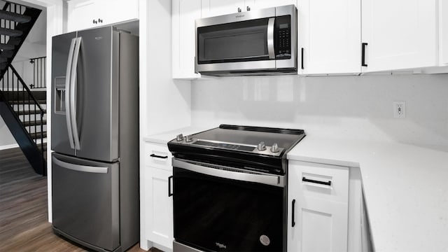 kitchen featuring dark wood-type flooring, stainless steel appliances, and white cabinets