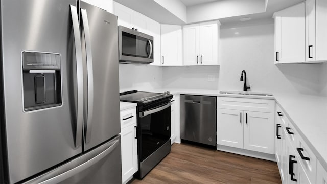 kitchen featuring appliances with stainless steel finishes, white cabinetry, sink, and dark wood-type flooring