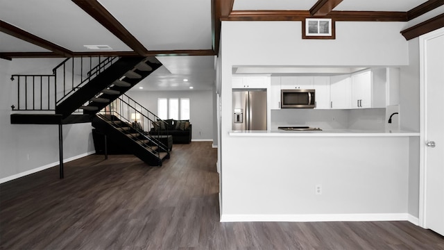 kitchen featuring beam ceiling, dark wood-type flooring, appliances with stainless steel finishes, and white cabinets