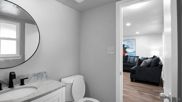 bathroom with vanity, toilet, and hardwood / wood-style floors