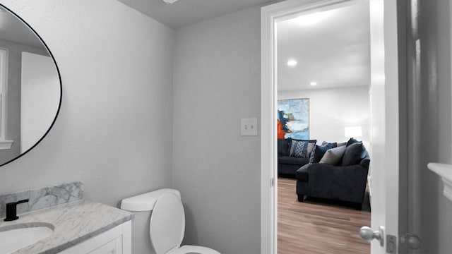 bathroom featuring toilet, hardwood / wood-style flooring, and vanity