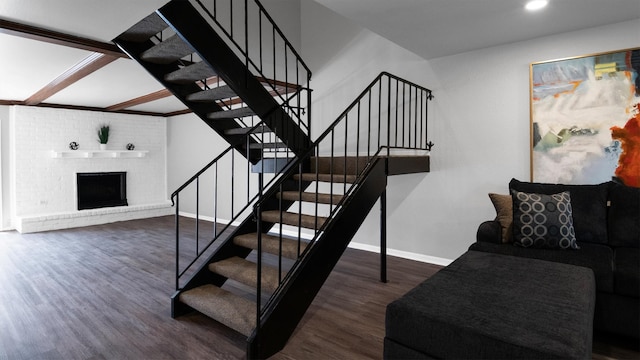 staircase with hardwood / wood-style floors and a brick fireplace