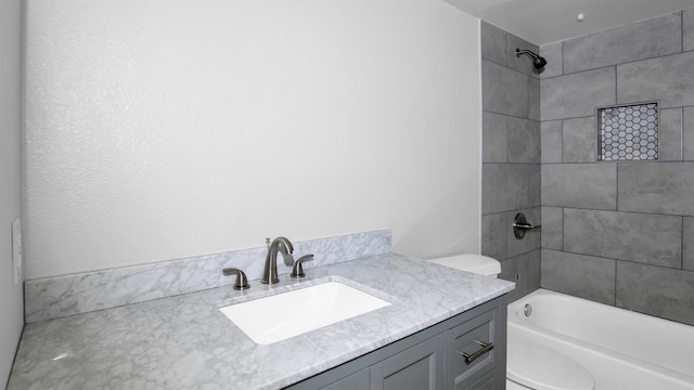 full bathroom featuring vanity, toilet, and tiled shower / bath combo