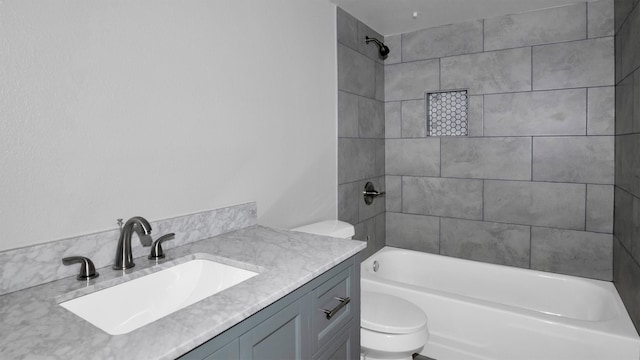 full bathroom featuring vanity, tiled shower / bath combo, and toilet