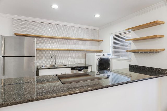 clothes washing area with washer / clothes dryer, crown molding, and sink