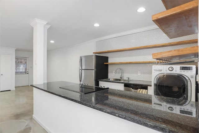 kitchen featuring decorative columns, ornamental molding, stainless steel appliances, sink, and washer / clothes dryer