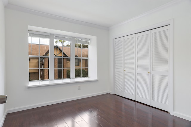 unfurnished bedroom featuring a closet, dark hardwood / wood-style flooring, and crown molding