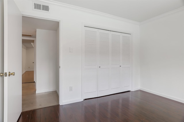 unfurnished bedroom with dark hardwood / wood-style floors, a closet, and ornamental molding