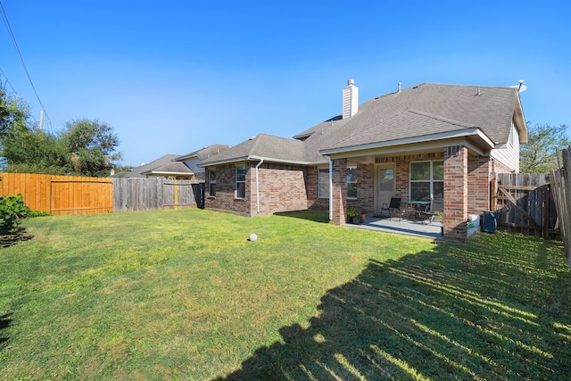 rear view of house with a patio area and a yard