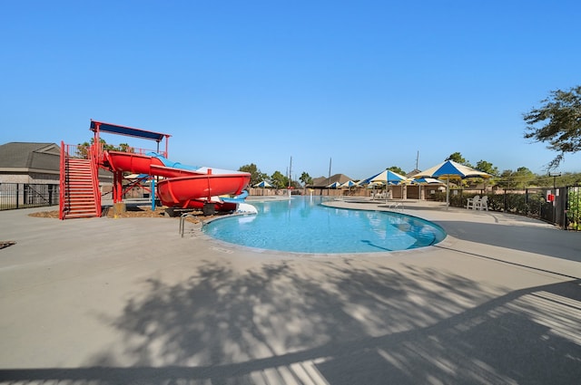 view of pool featuring a water slide and a patio