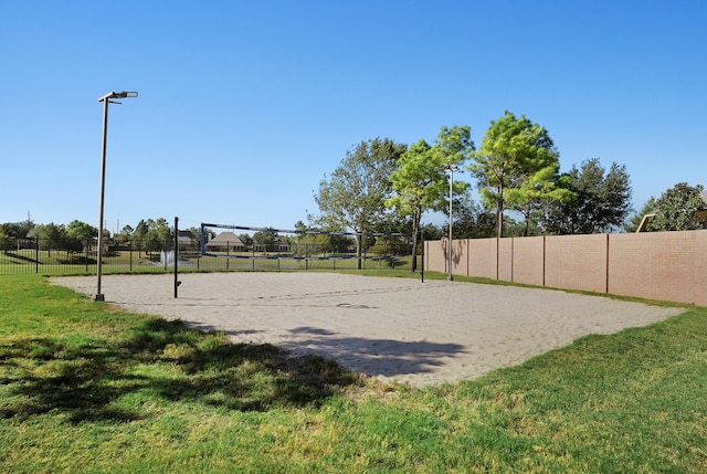 view of property's community with volleyball court and a lawn