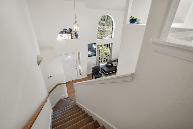 stairway featuring a towering ceiling