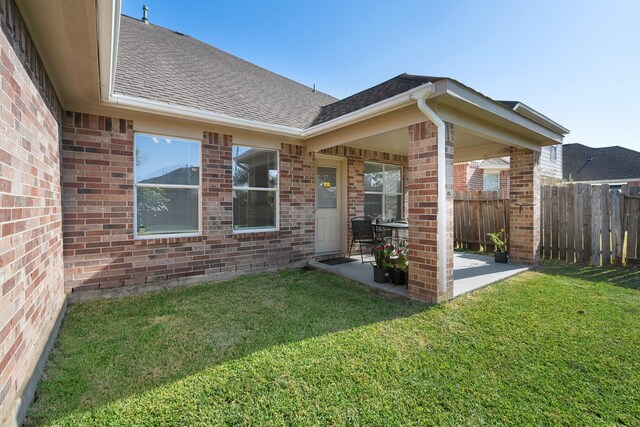 property entrance featuring a lawn and a patio area