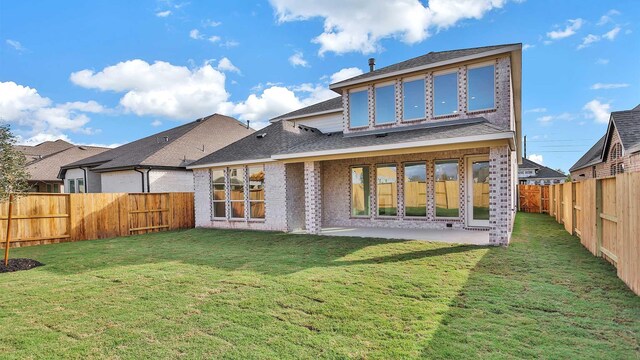 back of house featuring a patio area and a yard