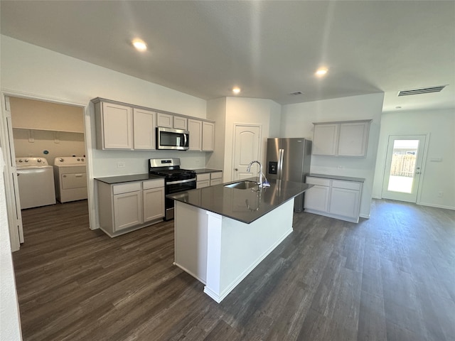 kitchen with dark hardwood / wood-style flooring, washing machine and dryer, sink, and appliances with stainless steel finishes