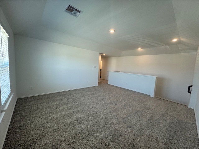 spare room with carpet and vaulted ceiling