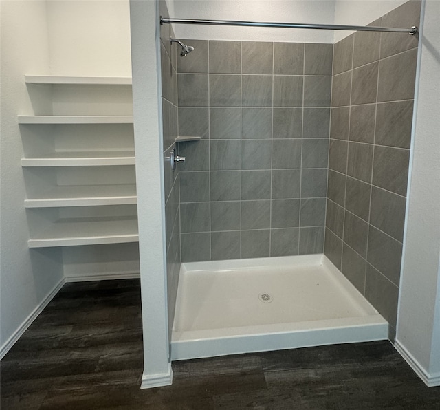 bathroom with hardwood / wood-style floors and a tile shower