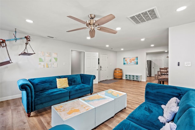 living room featuring ceiling fan and hardwood / wood-style floors