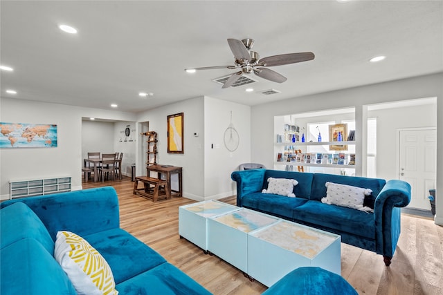 living room with light hardwood / wood-style floors and ceiling fan