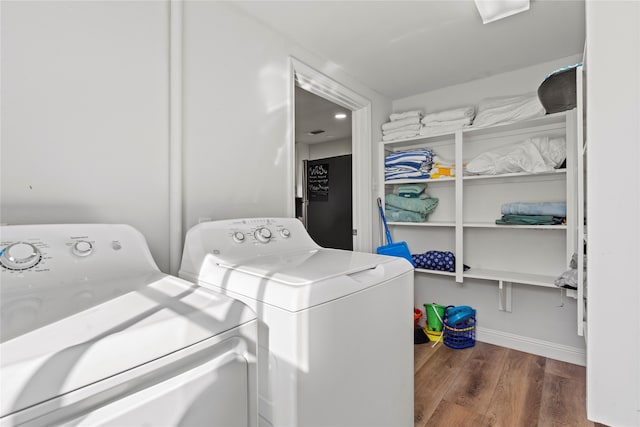 laundry room with independent washer and dryer and dark hardwood / wood-style flooring