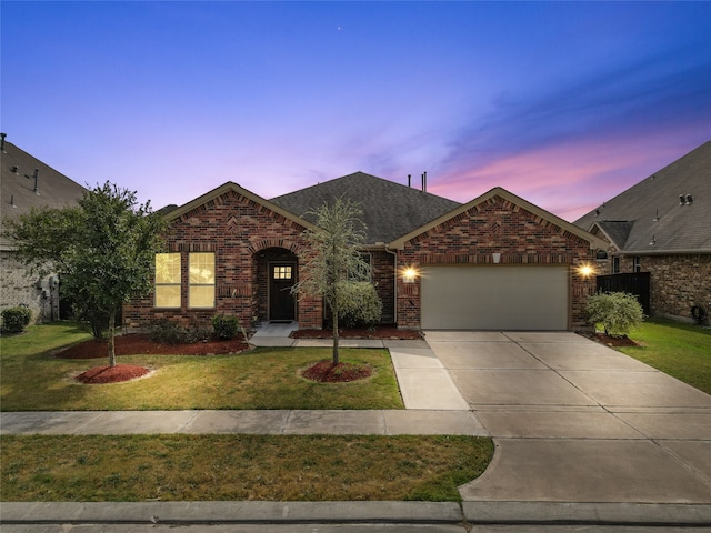 view of front of property with a garage and a lawn