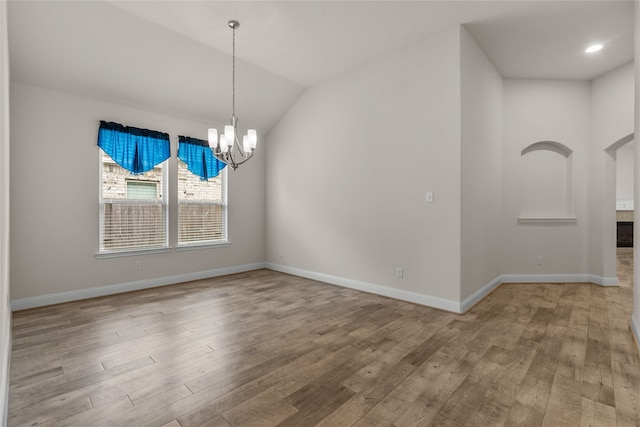 unfurnished dining area featuring light hardwood / wood-style flooring, a notable chandelier, and lofted ceiling