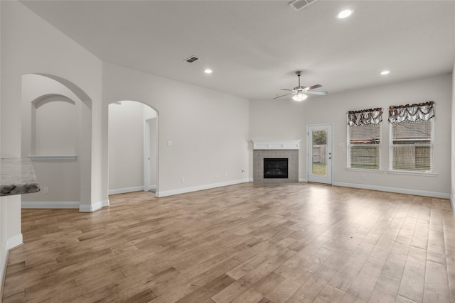 unfurnished living room featuring ceiling fan, light hardwood / wood-style flooring, and a fireplace